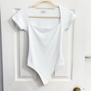 White Aritzia Babaton cap sleeve short sleeve bodysuit.